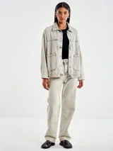 Chaqueta denim gris con botones en la delantera y dos bolsillos sin solapa tambien en el frente. Cuello camisero.