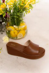 Sandalia marrón con plataforma forrada en cuero vacuno, diseño minimalista y base forrada en cuero. La altura total es de 6,5 cm con una plataforma delantera de 3 cm.