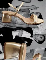 Sandalias doradas de fiesta con tiras finas y taco cuadrado bajo.