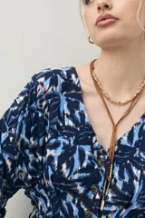 Vestido corto color marrón con estampado de hojas blancas, escote en V, mangas cortas y cintura marcada.