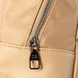Mochila color khaki, confeccionada en poliéster y poliuretano. Cuenta con un compartimento principal con cierre, un bolsillo interno con cierre y dos abiertos, y un bolsillo externo con cierre. Tiene correa regulable y herrajes plateados.