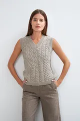 Chaleco tejido marrón con escote en v y sisas amplias. Diseño con diferentes puntos combinados en el frente.