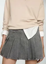 Minifalda gris de jean con diseño de tablas, tiro bajo y cierre lateral con cremallera.