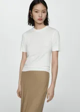 Jersey de punto fino color blanco, de manga corta y cuello redondo.