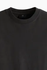 Remera negra de corte holgado con cuello redondo y mangas cortas. Estampado frontal con la inscripción "ORK XON NEW THE".
