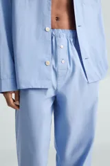 Pantalón de pijama celeste de algodón, corte relaxed fit, con cintura elástica ajustable con cordón interior, bolsillos laterales y detalle de vivos combinados a contraste en el bajo.