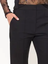 Pantalón negro de corte cropped y acampanado, confeccionado en tejido 4way.