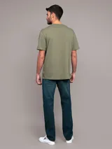 Remera verde militar de algodón, con cuello redondo y logo de Calvin Klein estampado en el pecho dentro de un recuadro blanco.
