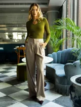 Pantalón palazzo de tiro alto, color beige, confeccionado en satén. Tiene pretina delantera con pasadores, botón y cierre, pretina trasera elastizada y bolsillos verticales delanteros.