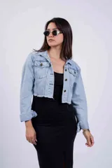 Campera de jean celeste de corte cropped, con cuello clásico, botones metálicos y mangas largas.