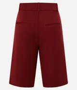 Bermuda de sastrería color borgoña, con cierre descentrado, trabillas en la cintura y pliegues delanteros.