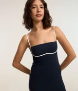 Vestido midi azul marino con breteles finos ajustables y bies contrastante blanco en el busto y ruedo. Confeccionado en algodón certificado BCI.