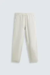 Pantalón relaxed fit color arena confeccionado en tejido de algodón y lino. Cintura elástica ajustable con cordón, bolsillos delanteros y traseros de plastrón.
