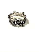 Anillo plateado con diseño de cruces y acabado envejecido.