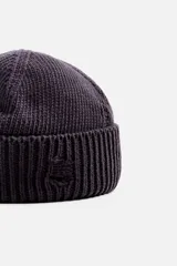 Gorro de lana tejido en punto morado oscuro, con vuelta y detalles rotos.
