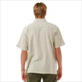 Camisa de manga corta de cuadros en tonos beige y marrón, con botones y bolsillo en el pecho.