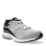 Championes New Balance modelo 2002R, color gris con detalles en negro y blanco. Confeccionados en gamuza y malla, con logo "N" característico en los laterales y entresuela con tecnología ABZORB.