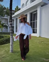 Poncho blanco de tejido de punto calado, con cuello redondo y mangas 3/4.