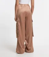 Pantalón wide leg de textura acetinada color café, con bolsillos cargo con solapa en los laterales y tira con moña en los bolsillos y en la barra. Cintura con trabillas y cierre por botón y cremallera.