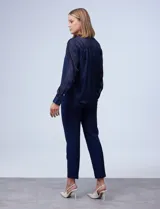 Blusa de gasa laminada azul con cuello a la base y abertura central con botones, incluye musculosa interna.