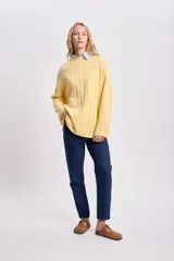 Sweater de punto tejido color amarillo, de corte holgado y cuello alto.