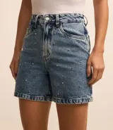 Bermuda de jeans azul con corte mom, tiro alto, cierre con botón y cremallera, y apliques de strass en el frente.
