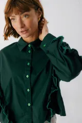 Camisa celeste con cuello clásico, cierre frontal con botones y mangas largas con volados.