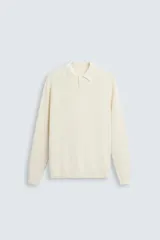 Polo relaxed fit de punto color crema, tejido en hilatura de algodón. Cuello solapa con cierre frontal de botonadura, manga larga y acabados en rib.