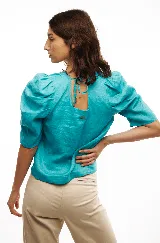 Blusa celeste de lino con escote cuadrado, mangas abullonadas y lazo en la espalda.