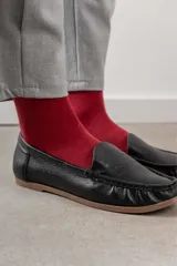 Mocasines de cuero color marrón claro con costuras a la vista.