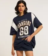 Remera deportiva oversize de algodón, color azul marino con mangas cortas blancas. Estampa frontal con el nombre "Los Angeles Chargers", el número "60" y el logo de la NFL.