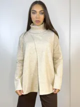 Sweater de punto beige con cuello alto y abertura frontal.