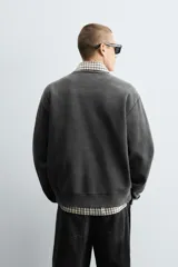Sudadera gris oscuro de corte relaxed fit, con cuello redondo, manga larga y efecto lavado.
