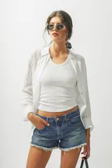 Camisa blanca de lino de manga larga con cuello clásico y cierre frontal con botones.