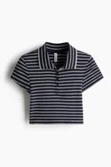 Remera polo corta de punto acanalado a rayas horizontales azul marino y blancas, con cuello clásico y tapeta de botones.