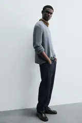 Sweater azul de punto con textura, corte holgado, cuello redondo y mangas largas con puños acanalados.