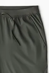 Pantalón deportivo de corte ajustado (slim fit) en tejido funcional DryMove™ color verde oscuro, con cintura elástica y cordón de ajuste oculto. Posee bolsillos al bies y piernas levemente ajustadas.