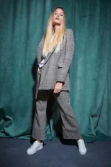 Conjunto sastrero a cuadros grises, compuesto por un blazer de corte clásico y un pantalón palazzo.