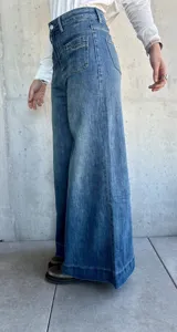 Pantalón de jean azul de corte pata de elefante, con bolsillos frontales tipo parche.