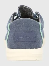 Alpargata negra con cordones elásticos y suela blanca con textura.