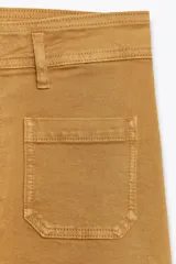 Pantalón de jean de tiro alto color negro con pierna ancha, bolsillos delanteros y traseros, y cierre frontal con cremallera y botón metálico.