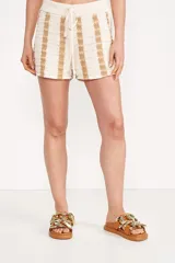 Short de punto color beige con rayas verticales en tono dorado, cintura elástica y cordón ajustable.