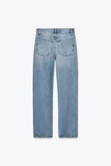 Pantalón de jean celeste de tiro alto, corte recto y largo hasta el tobillo. Tiene cinco bolsillos, trabillas en la cintura, efecto lavado y cierre frontal con cremallera y botón.