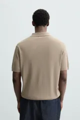 Polo verde salvia de punto canalé, corte regular fit, cuello solapa con cierre de botonadura y mangas cortas.