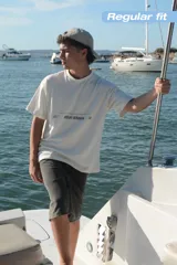 Remera color crema de corte recto y mangas cortas, con estampados en negro en el frente y la espalda.