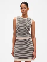 Musculosa a rayas horizontales en tonos beige y negro, con cuello redondo y sisas con terminación ondulada.