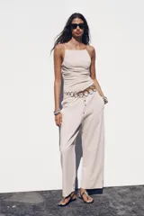Pantalón ancho color beige, de tiro medio y cintura ajustable con cordones.