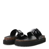 Sandalias planas color gris con hebilla metálica negra, tira ancha sobre el empeine y tira entre los dedos. Plataforma con base de corcho y suela de goma negra.