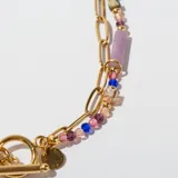 Collar dorado de doble cadena, una de eslabones y otra con cuentas de colores y dije circular.