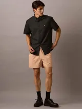 Camisa negra de manga corta, corte clásico, con cuello abotonado y logo de Calvin Klein bordado en el pecho.